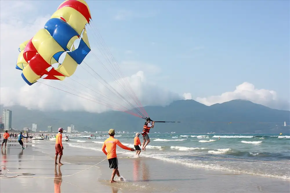Visitors enjoying a parasailing adventure. (Source: Bao Lao Dong)