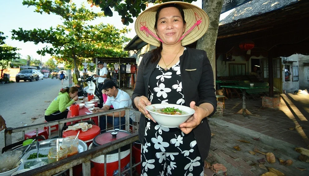 A vendor preparing clam porridge from a traditional roadside cart in Hoi An (Source: Collected)