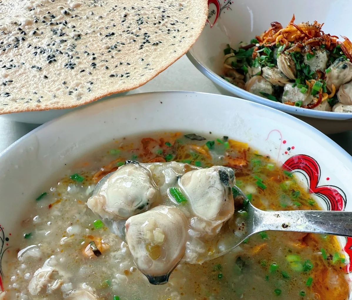Traditional preparation of Hoi An clam porridge using fresh river clams and annatto oil (Source: Collected)