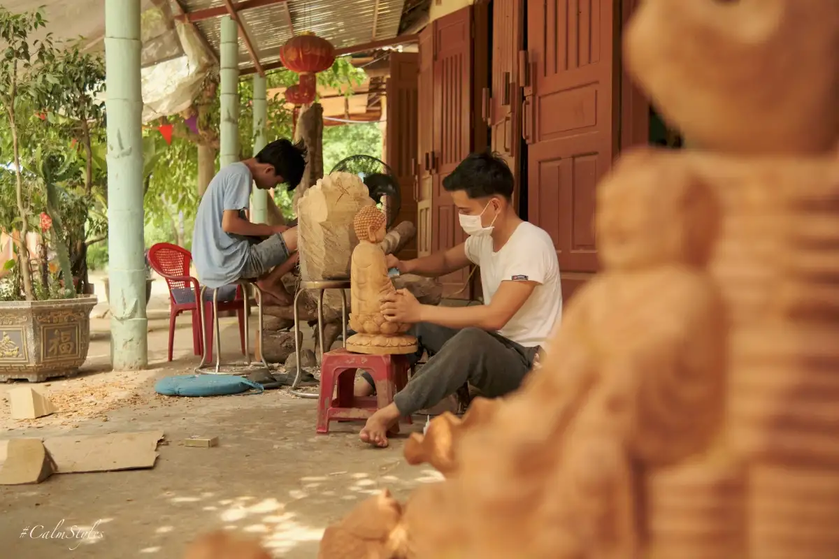 Artisan hand-carving a wooden zodiac souvenir in Kim Bong village