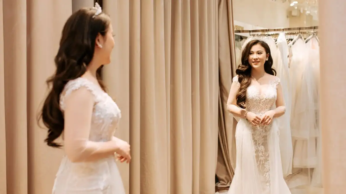 The bride may need to try on multiple dresses, stand for fittings, and move frequently during the process. (Source: Cong Studio)