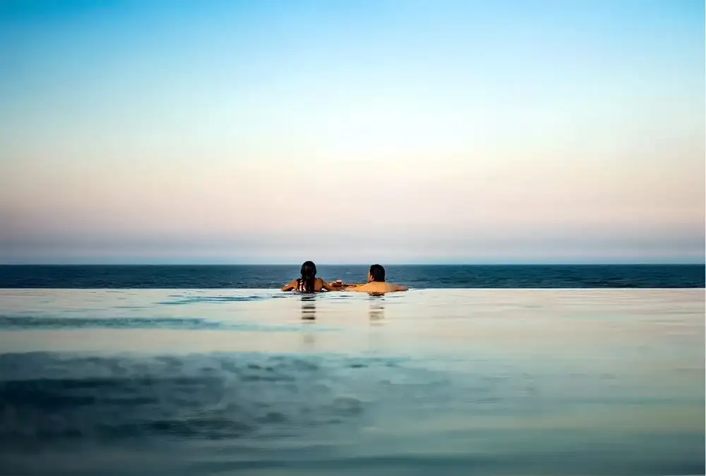 Sunset over the infinity pool at Bliss Hoi An Beach Resort & Wellness, where guests can unwind after a day exploring Central Vietnam.