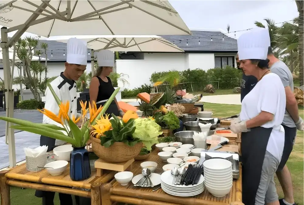 Guests learn to prepare Vietnamese dishes during a hands-on cooking class at Bliss Hoi An Beach Resort & Wellness