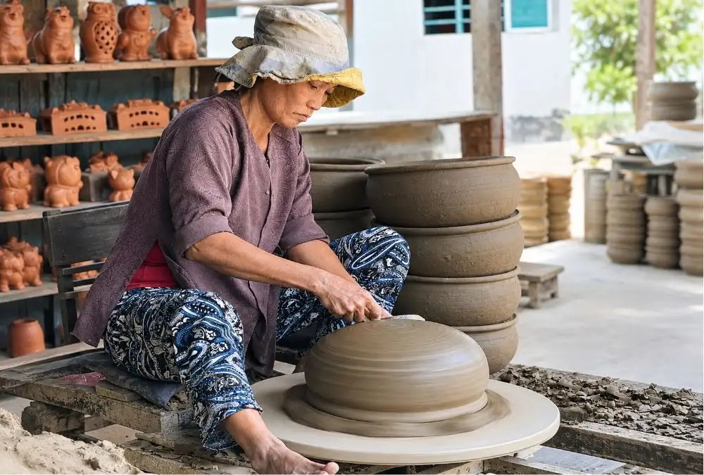 A local artisan shapes clay at Thanh Ha Pottery Village, where visitors can learn about traditional ceramics and try hands-on pottery making (Source: mia.vn)