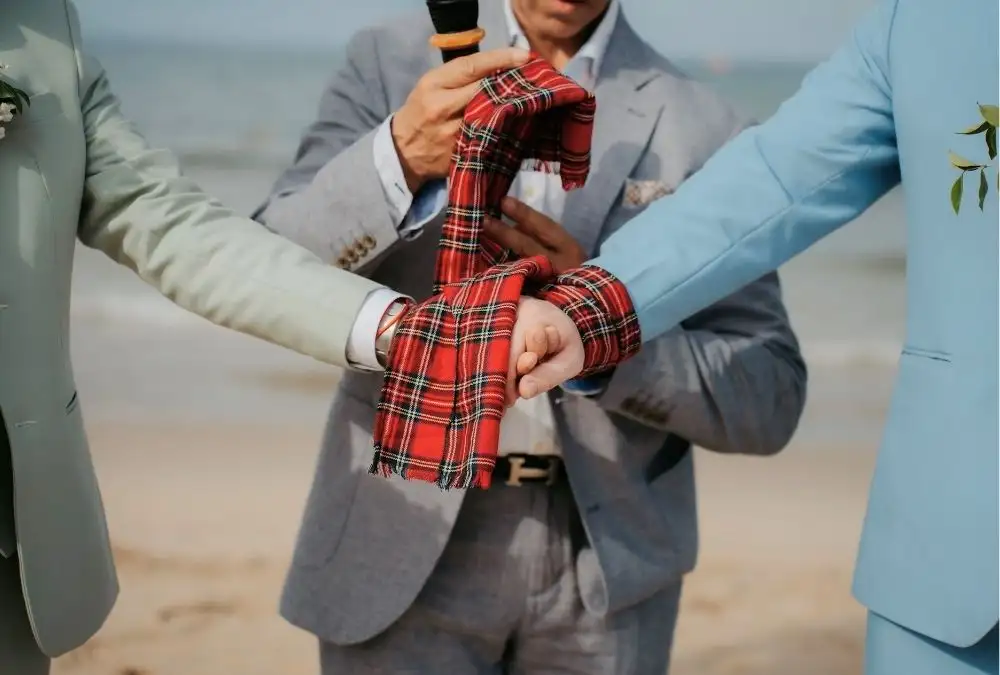 A tartan cloth binds the couple’s hands during the handfasting